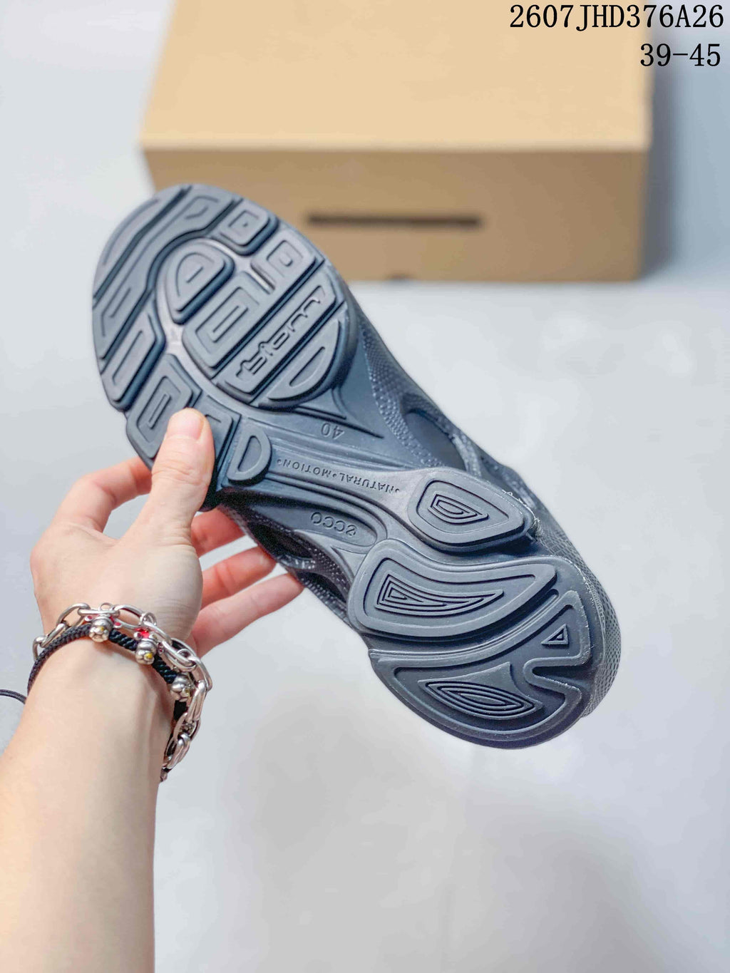 Underside view of the black sneaker showing the patterned textured outsole and ECCO branding.