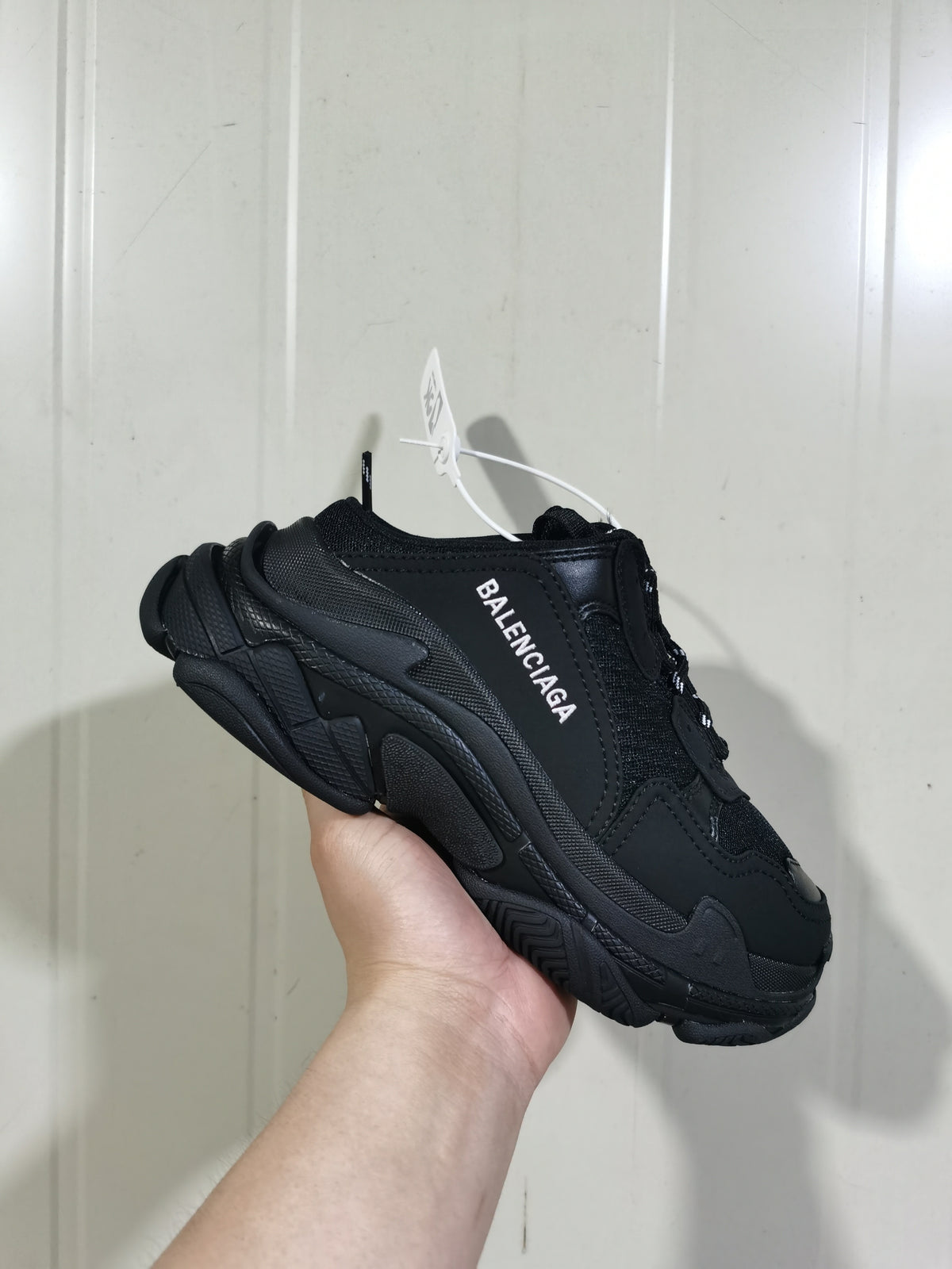 Black Balenciaga mule-style sneaker shown from the outer side, with layered panels, chunky sole, and white side branding.