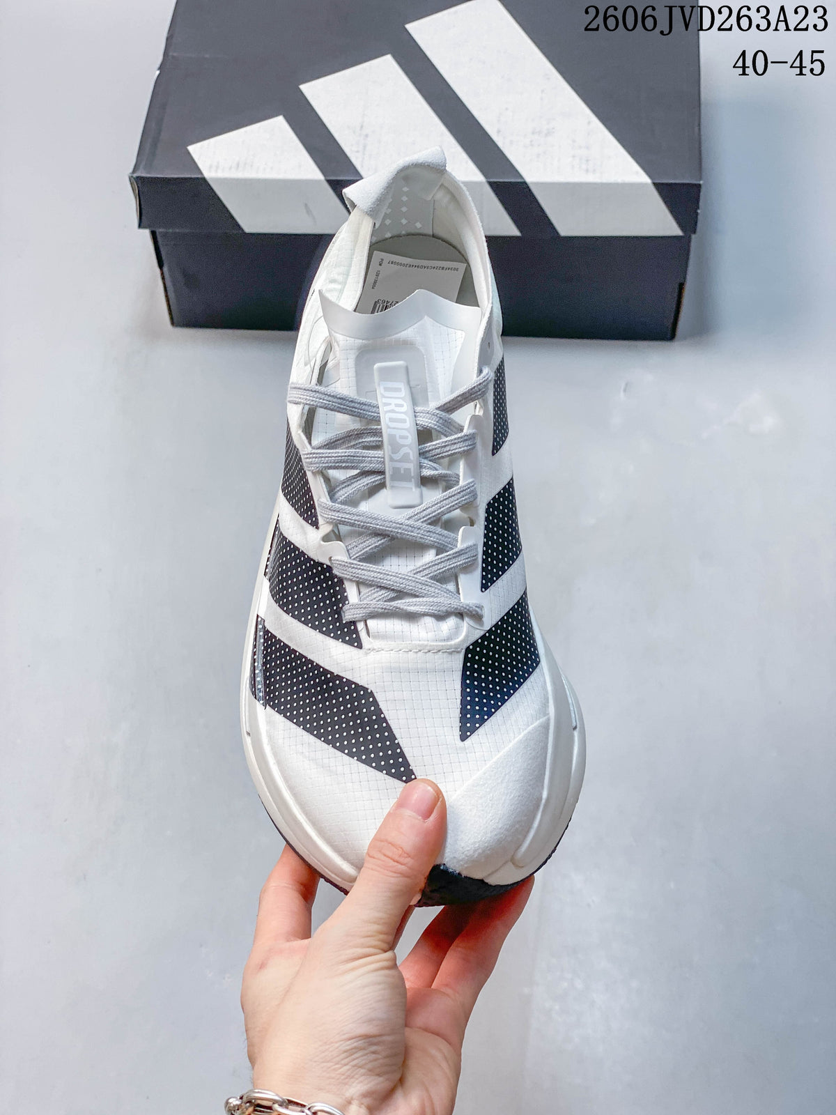 Top view of the white Adidas Adizero Dropset Elite shoe showing its laces and dark dotted panels; image text shows sizes 40–45.