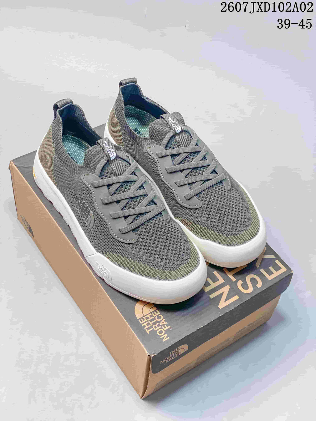Pair of gray and olive The North Face Dune sneakers with lace-up fronts and light soles.