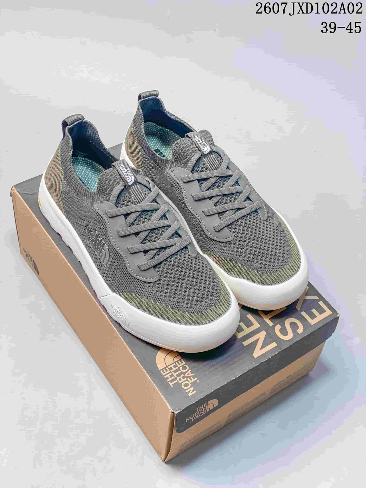 Pair of gray and olive The North Face Dune sneakers with lace-up fronts and light soles.