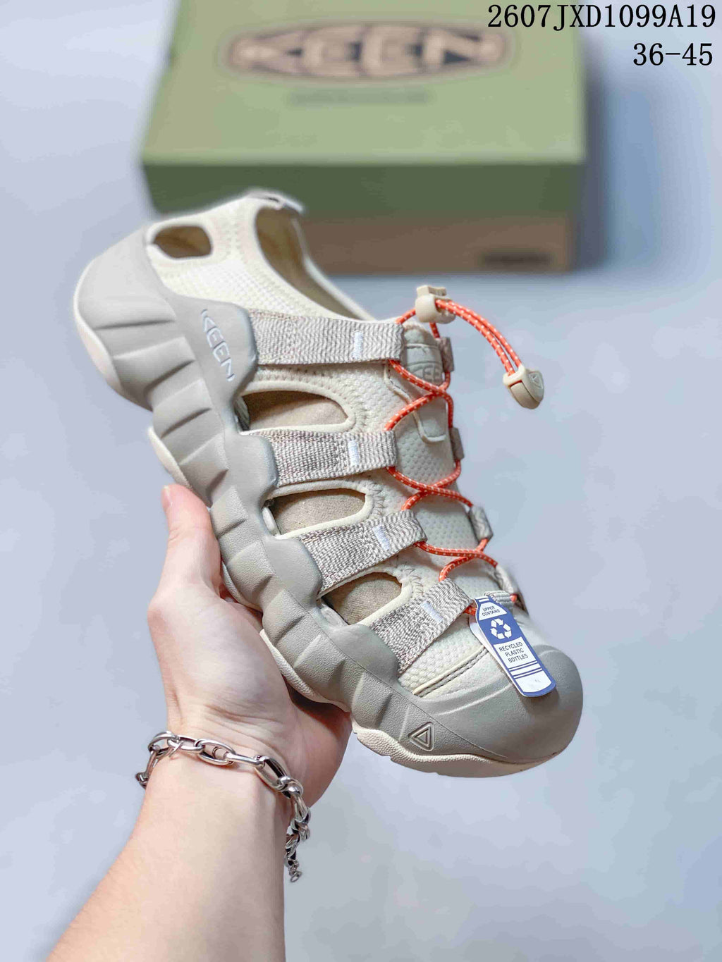 White and light gray Keen sandal with orange quick-lacing cord, open panels and a protective toe bumper; the image includes the size range 36–45.