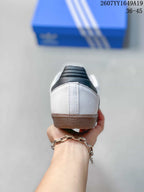 Rear view of the white sneakers showing the padded black-and-white heel collars and gum-colored heel sections.