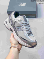 Angled close-up of the white, grey and dark blue New Balance 509 sneaker, with ABZORB text visible on the heel area.