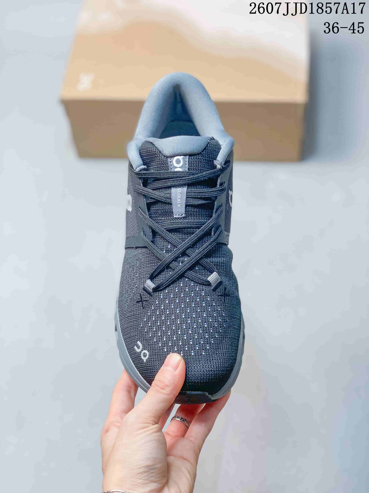 Front view of the dark gray sneaker showing the perforated toe area, laces, padded tongue, and On branding.
