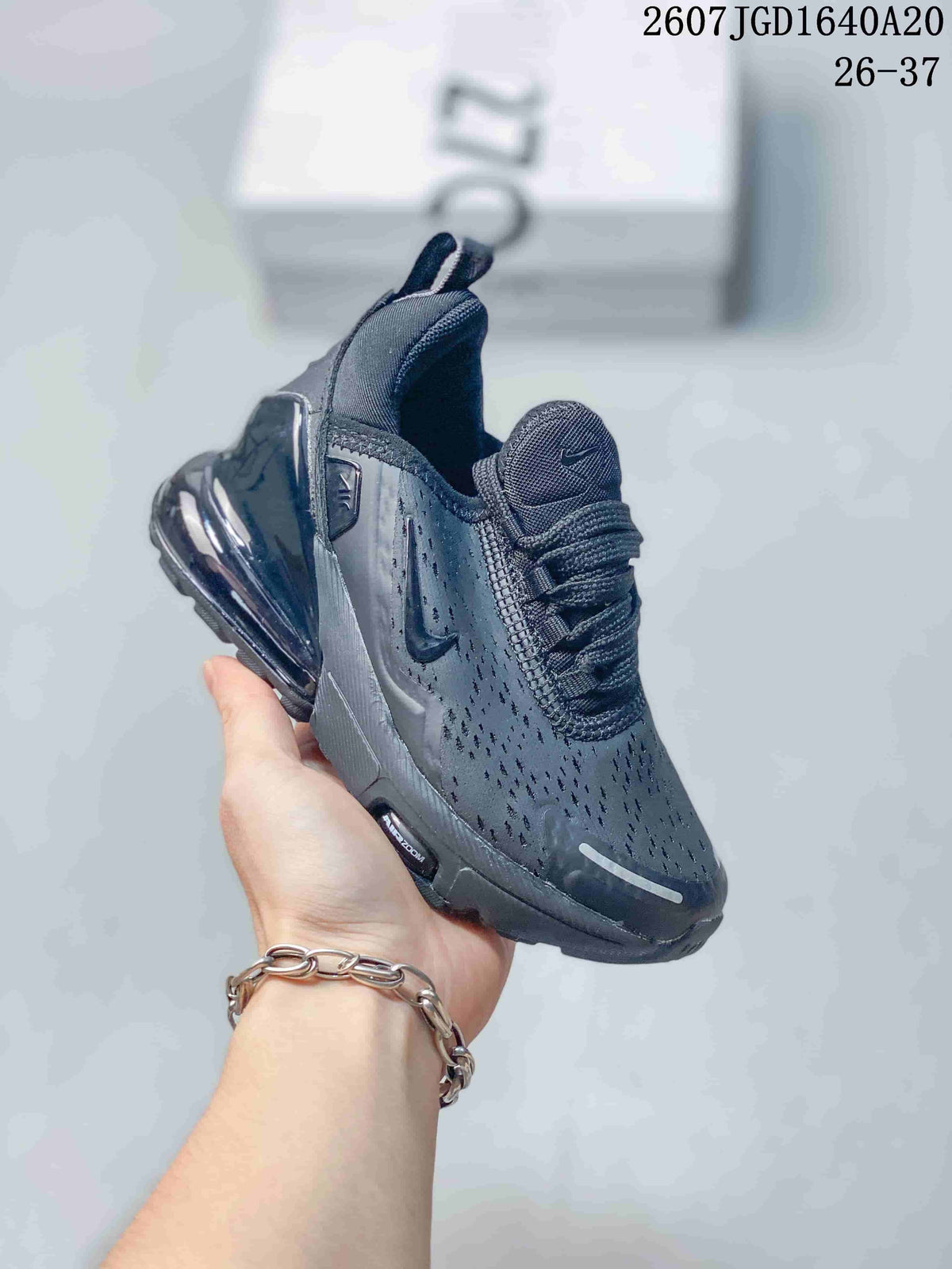 Three-quarter side view of the black Nike Air Max 270 sneaker with perforated upper, Swoosh branding, and glossy heel air unit.