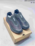 Pair of dark navy and black DESCENTE slip-on sneakers displayed on a shoe box; image text shows style code 2607JLD245A25 and size range 36–46.