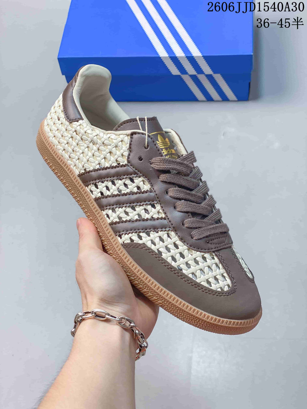 Angled view of the ivory and taupe-brown low-top sneaker