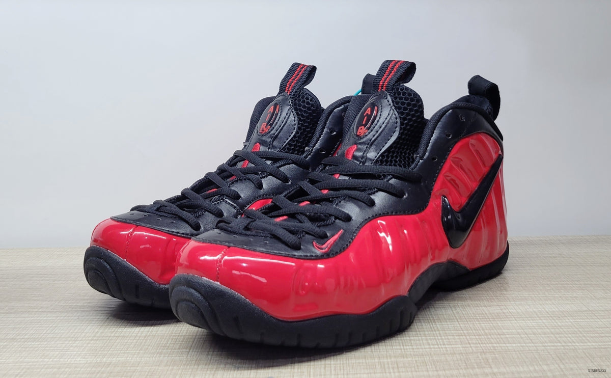 Angled front view of red and black Nike Foamposite Pro sneakers