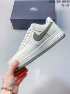 Side view of the low-top sneaker with a sage-green swoosh and white upper