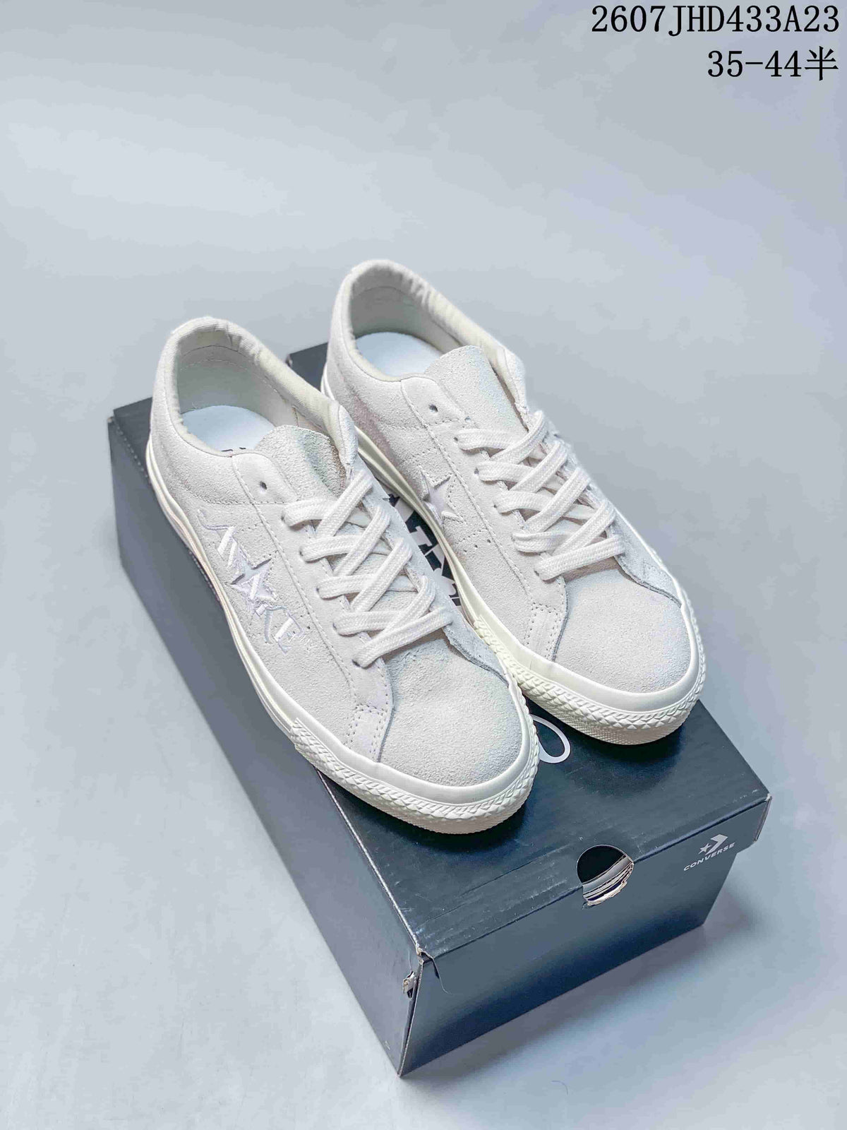 Pair of white low-top Converse All Star sneakers displayed on a shoebox; image text shows style code 2607JHD433A23 and size range 35–44.