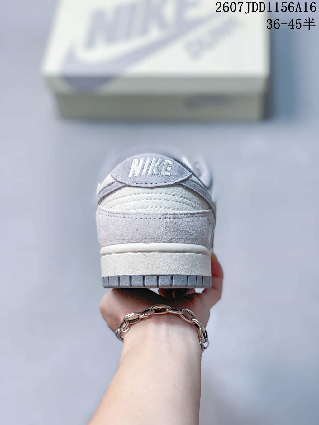 Rear view of a Nike SB Dunk Low sneaker showing the padded heel collar, layered heel panels and grey outsole edge.