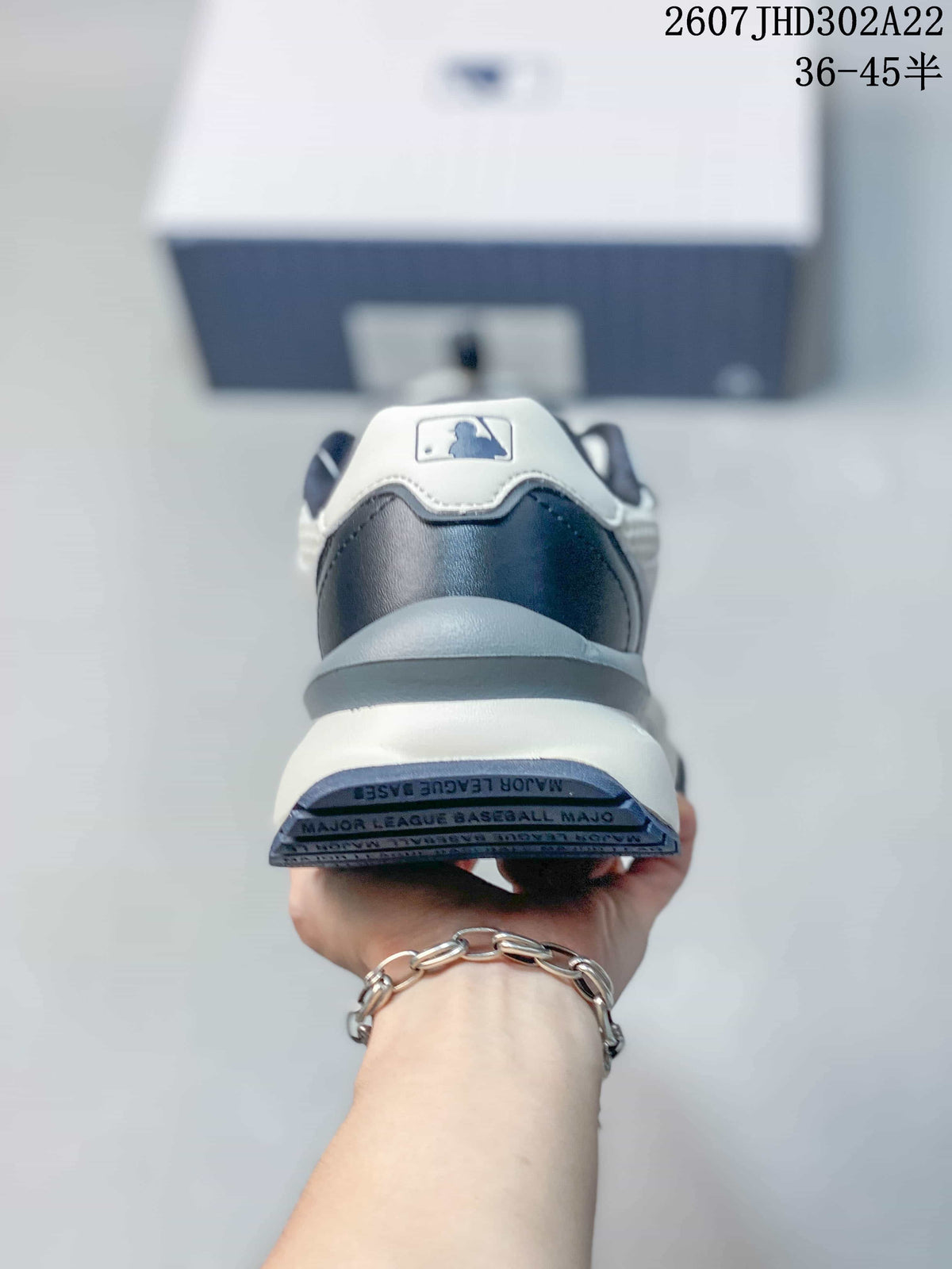 Rear view of the sneaker showing the navy heel panel, white collar detail, thick midsole, and outsole markings.