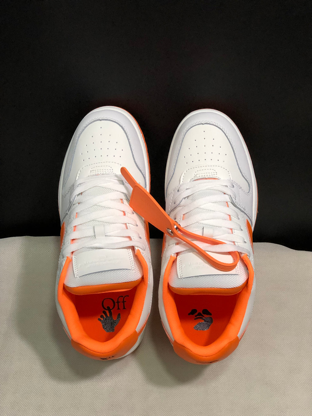 Top view showing white laces, perforated toe boxes, orange interior lining, and printed insole graphics.