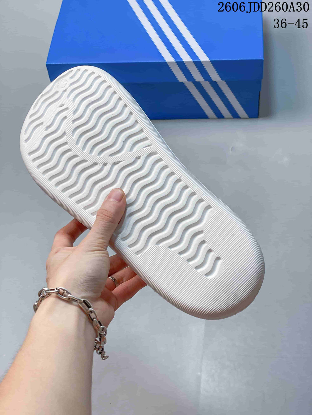 Underside of the white mule clog showing a wavy textured outsole