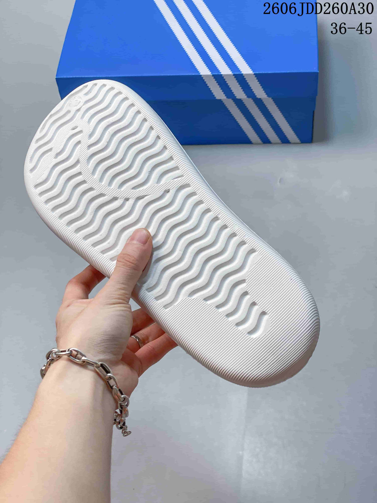 Underside of the white mule clog showing a wavy textured outsole