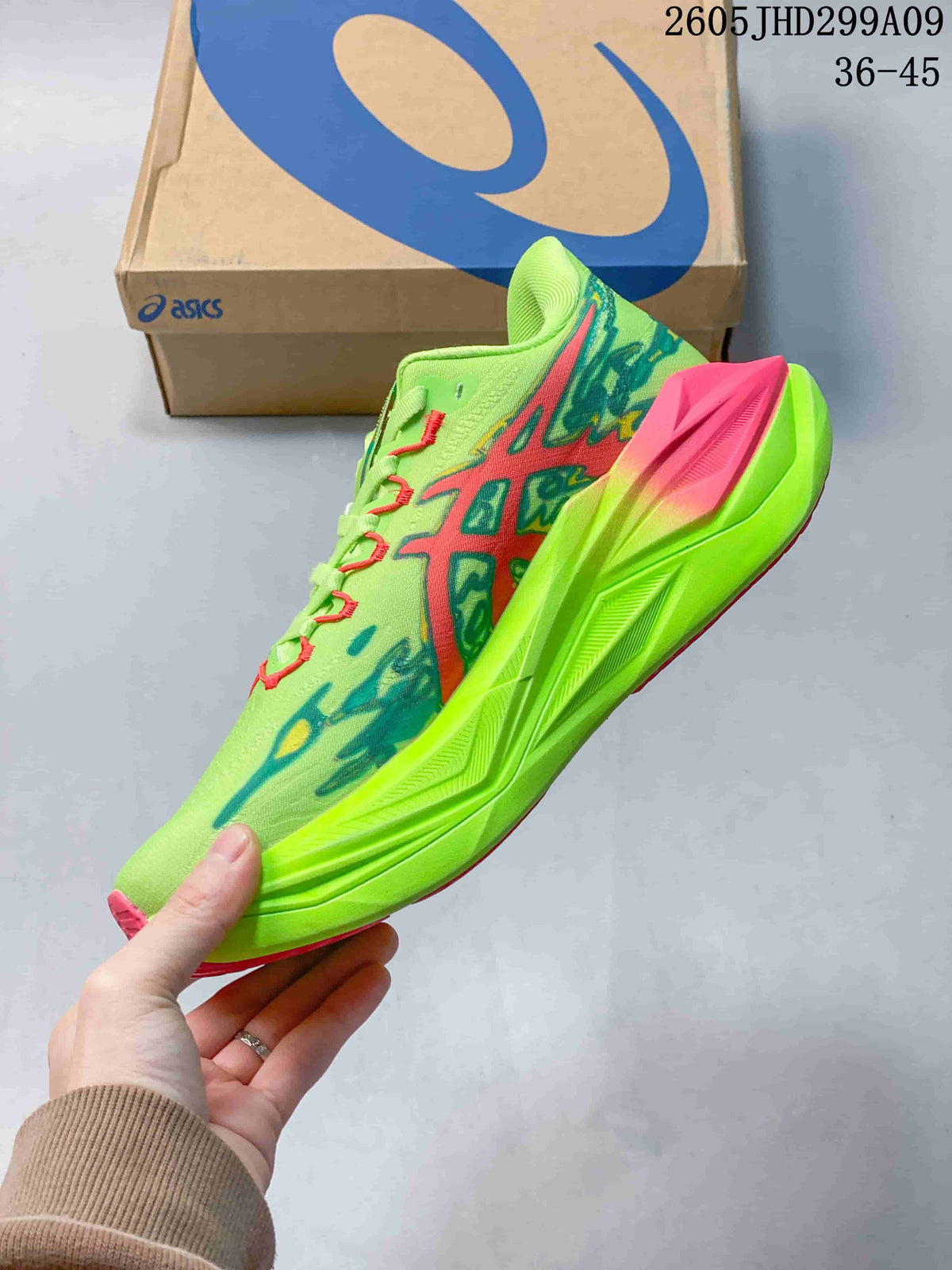 Side view showing the lime green upper, teal and pink graphics, and sculpted midsole