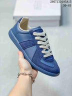 Close side view of a blue paneled sneaker with white laces and a matching textured outsole.