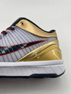 Close-up of the gold heel collar, striped side panel, and white midsole.