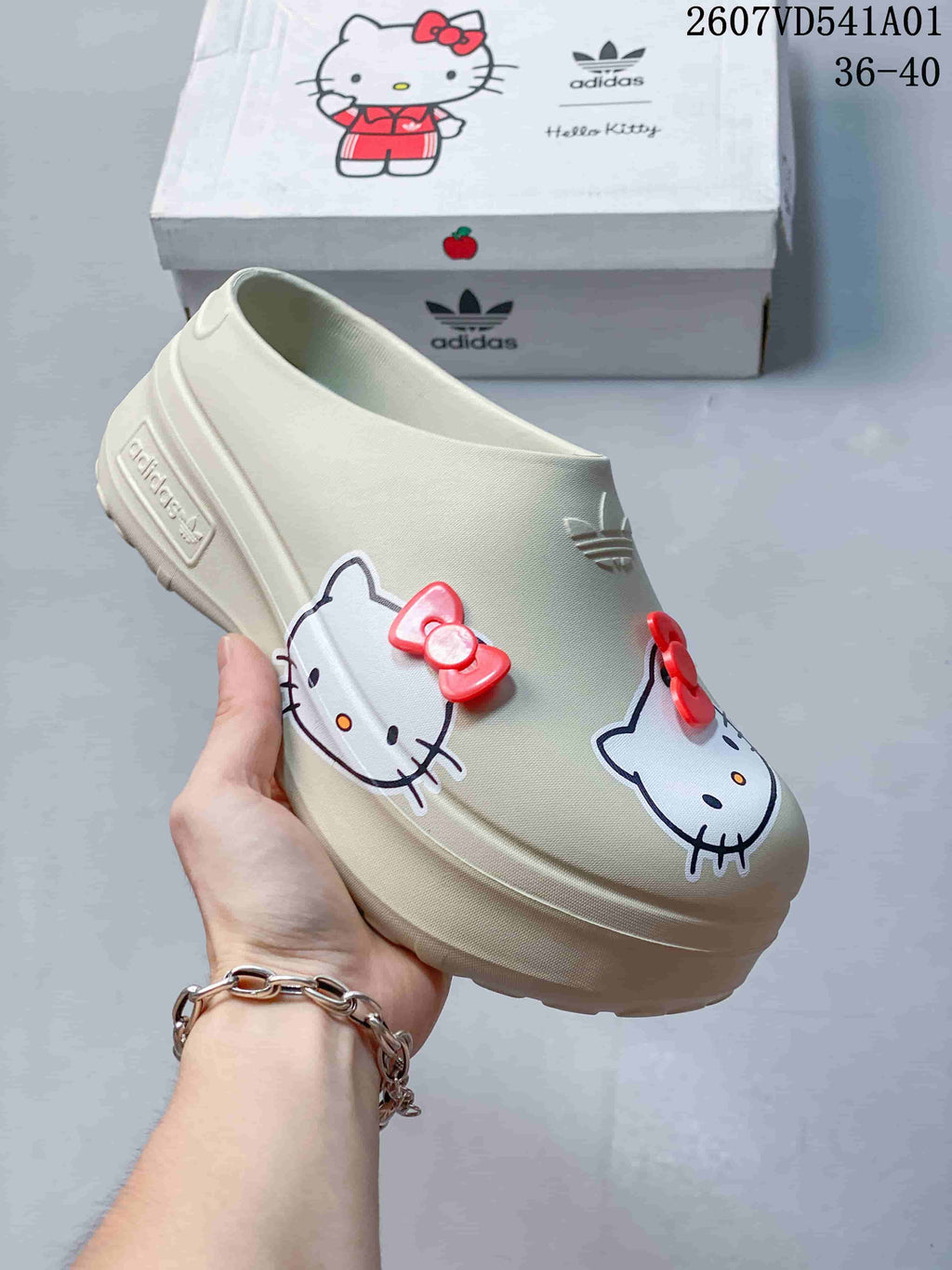 Angled view of a cream adidas x Hello Kitty mule clog with raised sole and character graphics