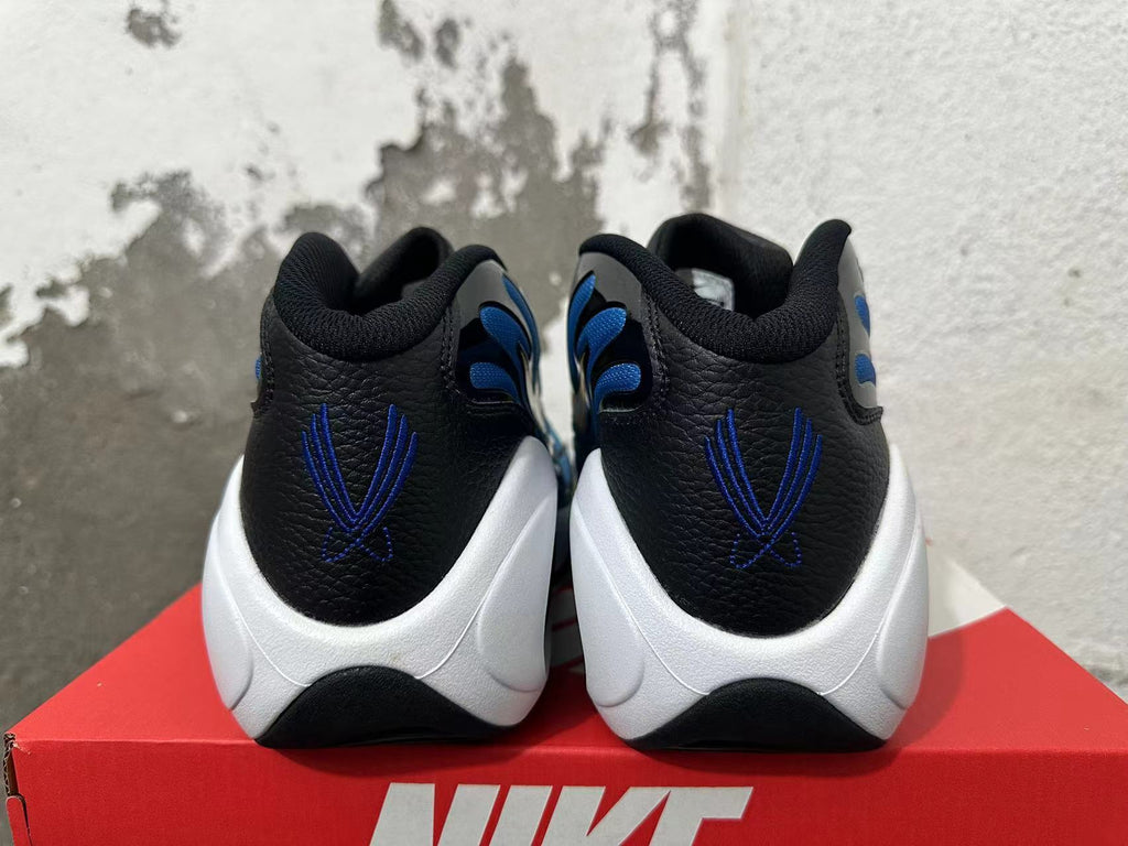 Rear view of blue, black, and white Nike sneakers with blue heel embroidery and a white sculpted midsole.