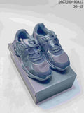 Pair of dark Onitsuka Tiger TIGRUN sneakers displayed on a shoebox, showing the layered upper, mesh panels and chunky sole.