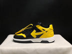 Outer side profile of a black and yellow low-top sneaker with yellow side detailing and a white midsole.