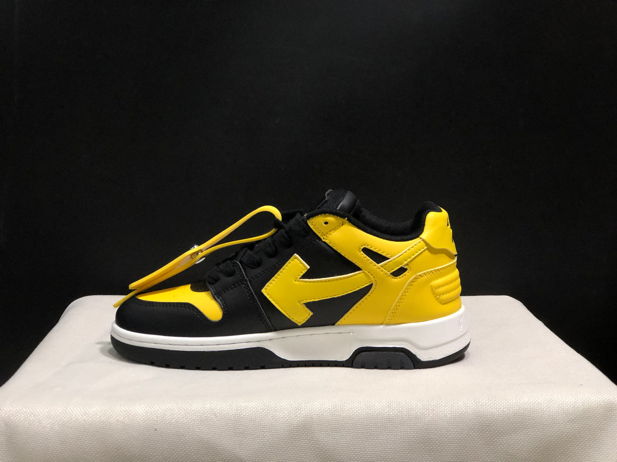 Outer side profile of a black and yellow low-top sneaker with yellow side detailing and a white midsole.