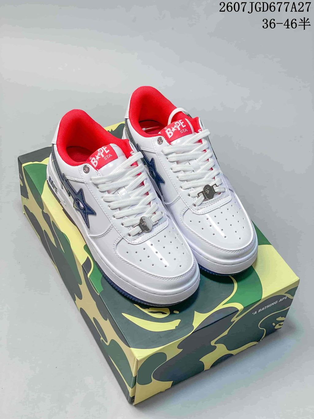 Pair of white and blue BAPE Sta low-top sneakers displayed on a camouflage-patterned shoebox.