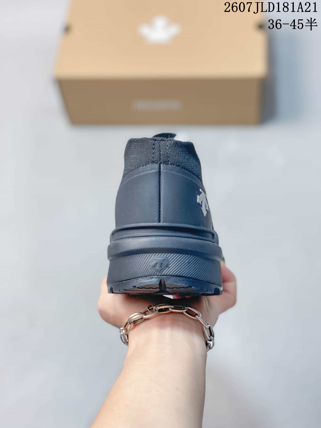 Rear view of a black slip-on sneaker showing the heel structure and raised sole.