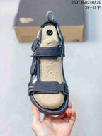 Top view of the open-toe sandal showing the tan footbed, black straps, buckles, and The North Face branding.