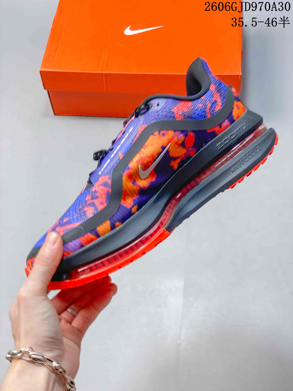 Side view of the patterned Nike running shoe with a dark midsole and visible cushioning element