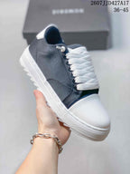 Side close-up of a navy sneaker showing the dark upper, white laces, contrast stitching, textured toe panel, and white sole.