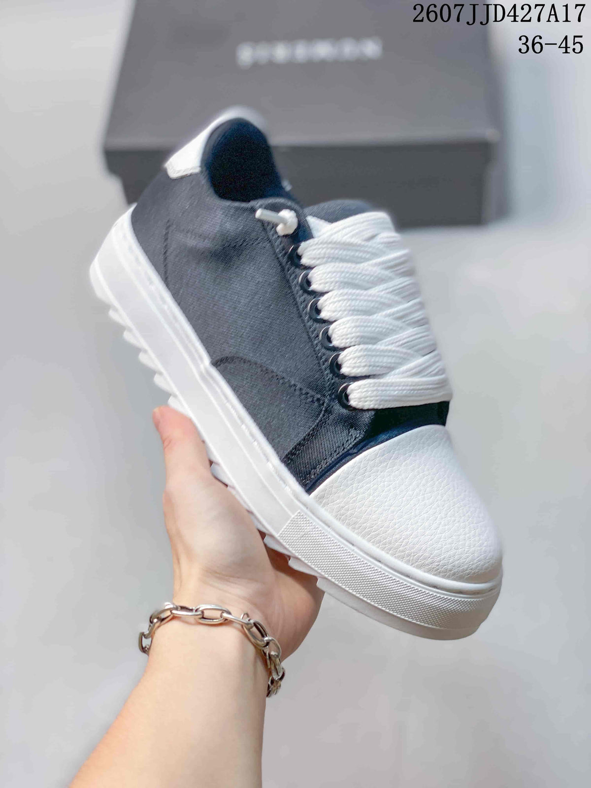 Side close-up of a navy sneaker showing the dark upper, white laces, contrast stitching, textured toe panel, and white sole.