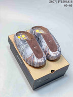 Pair of brown and gray marbled Nike Mind 001 slip-on sandals displayed on a presentation box; image text shows style code 2607JJY1586A16 and size range 40–46.