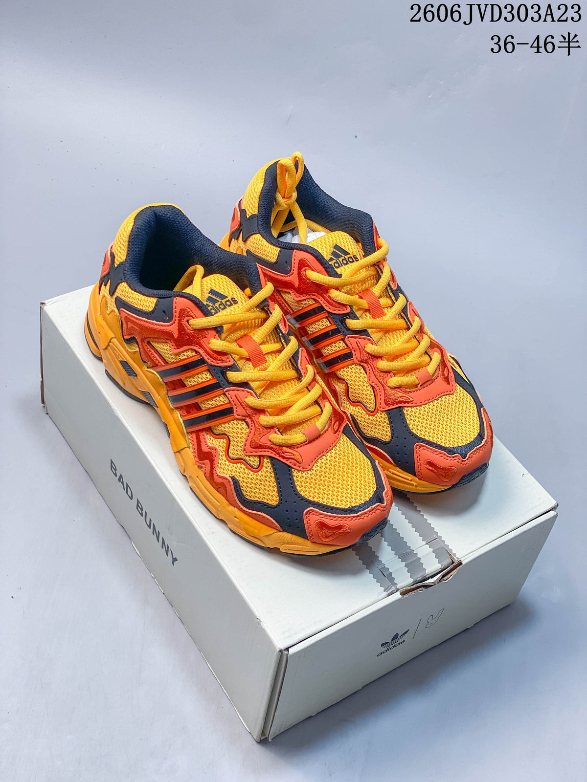 Pair of yellow, orange, and navy Bad Bunny x adidas Response CL sneakers on a branded box