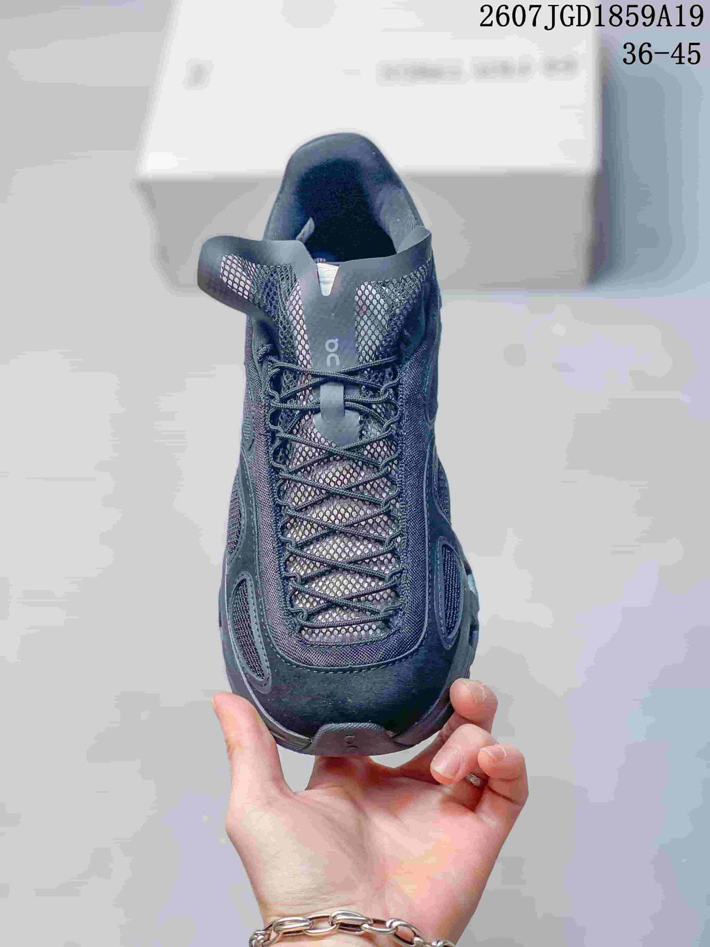 Front view of the dark sneaker showing the mesh tongue, crisscross lacing, padded collar, and rounded toe.