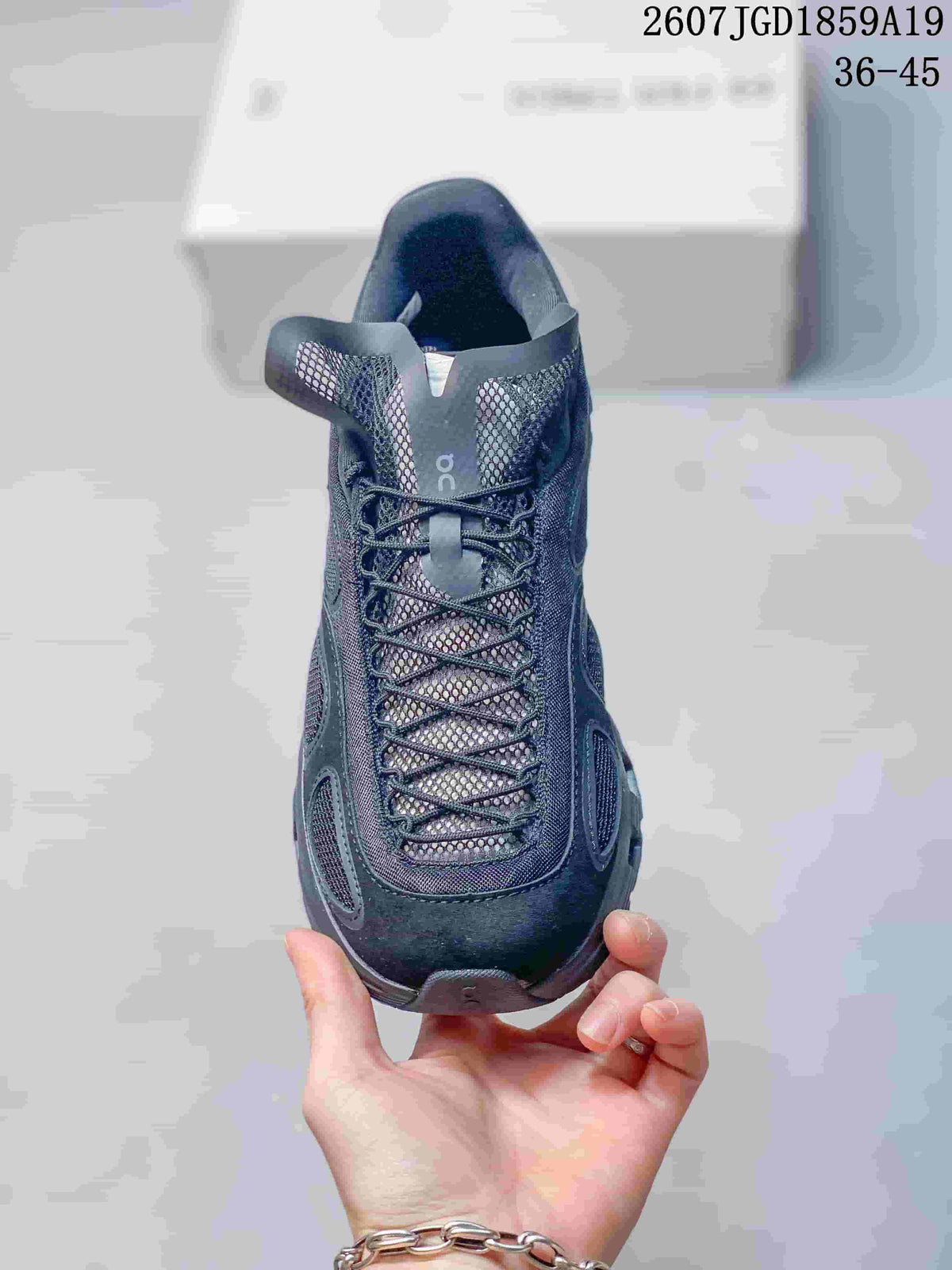 Front view of the dark sneaker showing the mesh tongue, crisscross lacing, padded collar, and rounded toe.