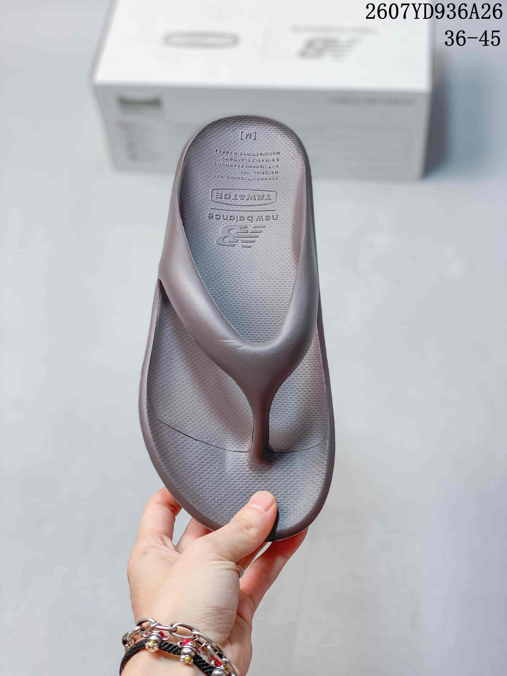 Top view of one New Balance thong sandal showing the textured footbed, toe post, and insole branding.