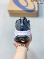 Rear view of the dark low-top sneaker showing the padded heel collar, pull tab and white midsole.