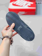 Close view of the black patterned rubber outsole with zigzag tread and a Nike detail.