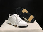 Angled view of the white sneakers with one shoe lifted to show the black treaded outsole and gum-colored sections.