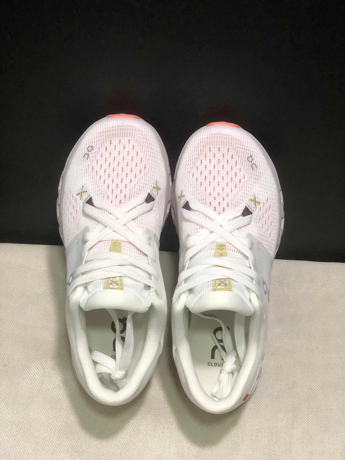 Top view showing the textured toe boxes, white laces, and contrasting coral outsole edges.