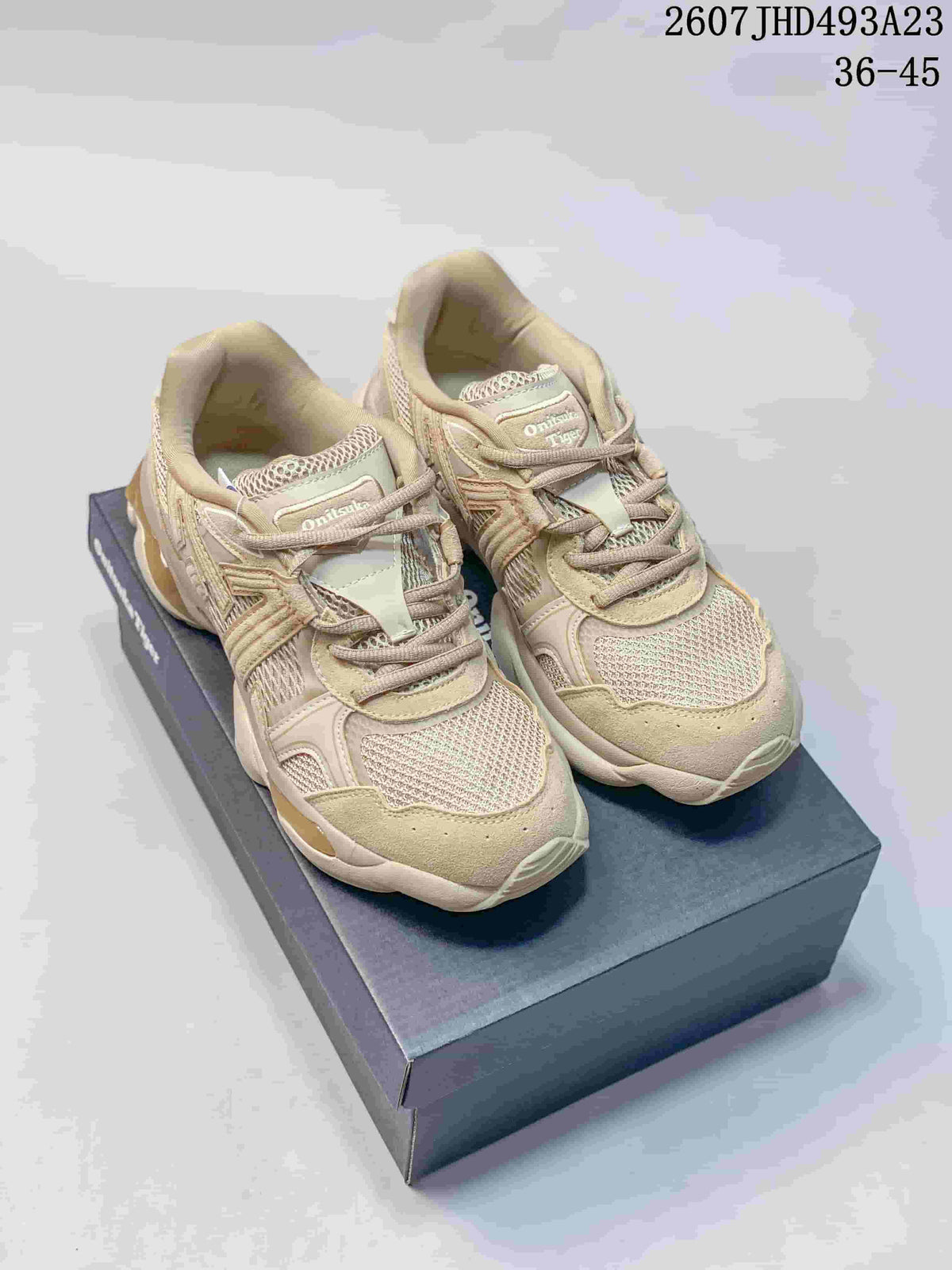 Pair of beige and cream Onitsuka Tiger TIGRUN sneakers displayed on a shoe box, with the source-listed code and size range visible above.