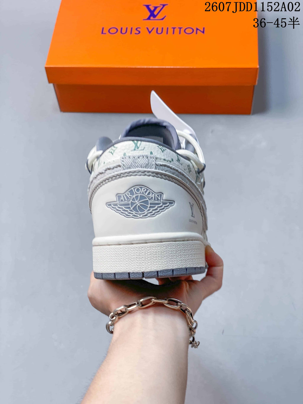 Rear view of a white and gray low-top sneaker showing heel details and patterned panels.