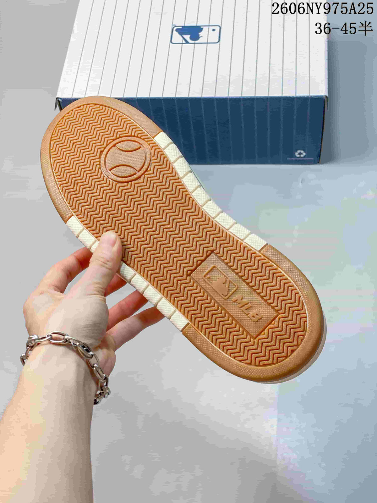 Underside of the sneaker showing a gum-colored outsole with a repeating herringbone tread pattern.
