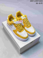 Pair of yellow and white Nike Air Force 1 low-top sneakers viewed from above on a shoebox; image marks the size range 36–45.5 and style code JD972A02.