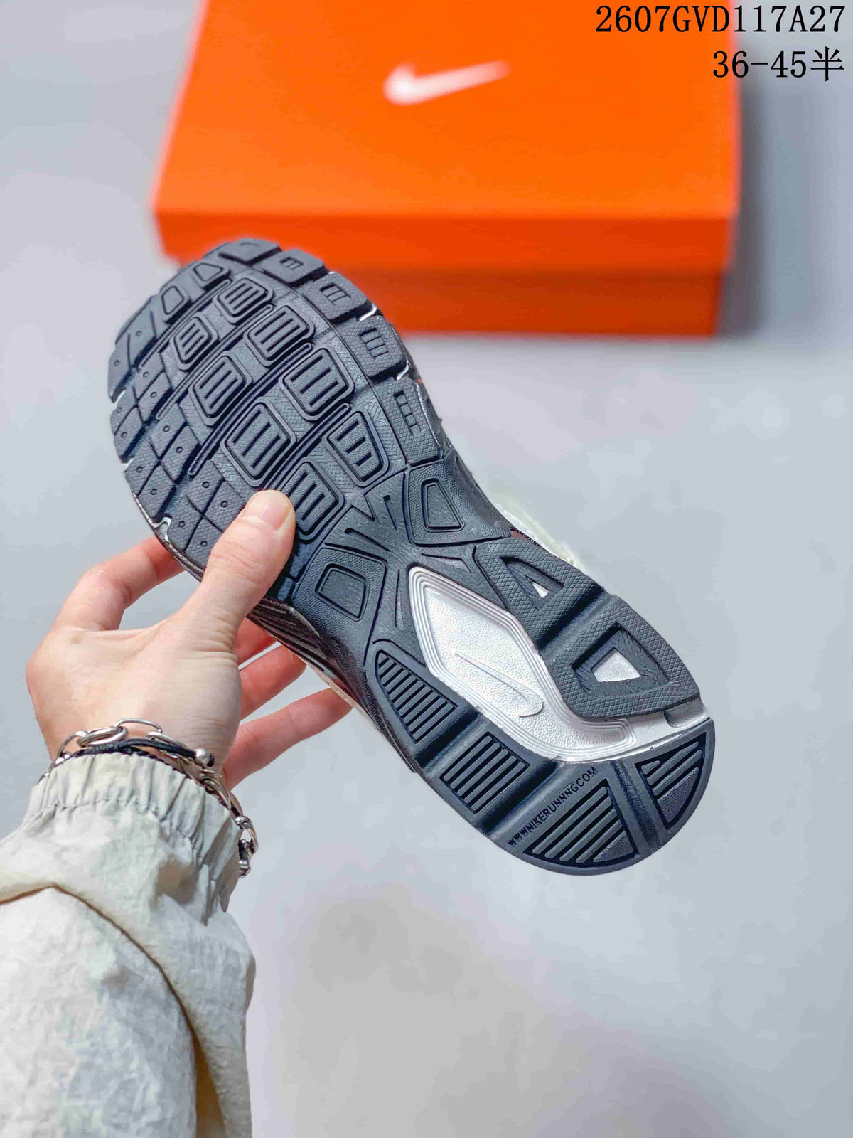Close-up of the dark outsole showing geometric tread blocks and textured traction patterns.