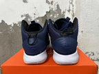 Rear view of navy Nike basketball shoes showing heel details and white outsoles