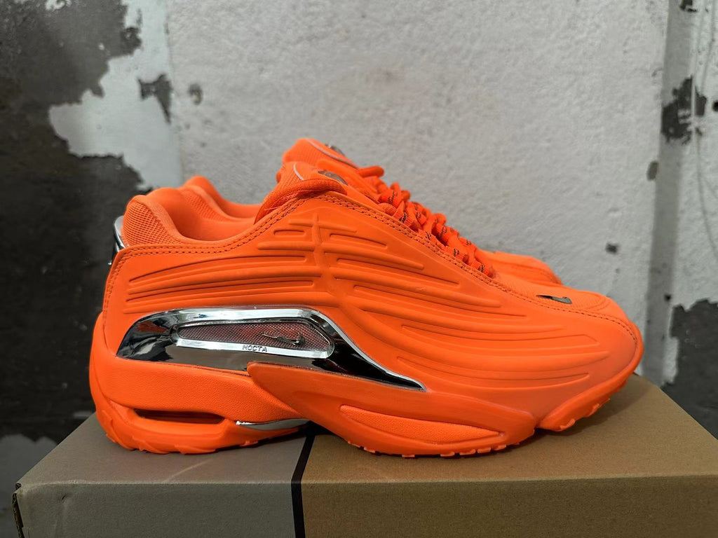Side view showing sculpted orange detailing and a silver-tone NOCTA accent.
